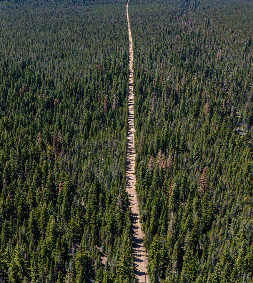 Man Using Measuring Tape in Factory Setting Man Using Measuring Tape in Factory Setting